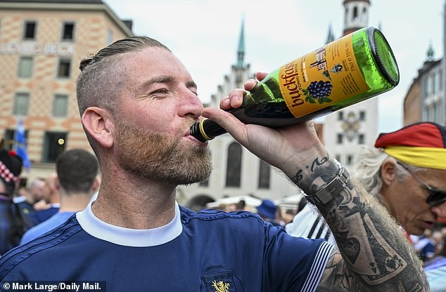 A Scotland fan drinks Buckfast in the Marienplatz in Munich today ahead of tonight's match