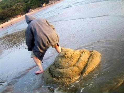 Image of person standing over massive pile of sand that makes them look like they just took a giant shit on the ground