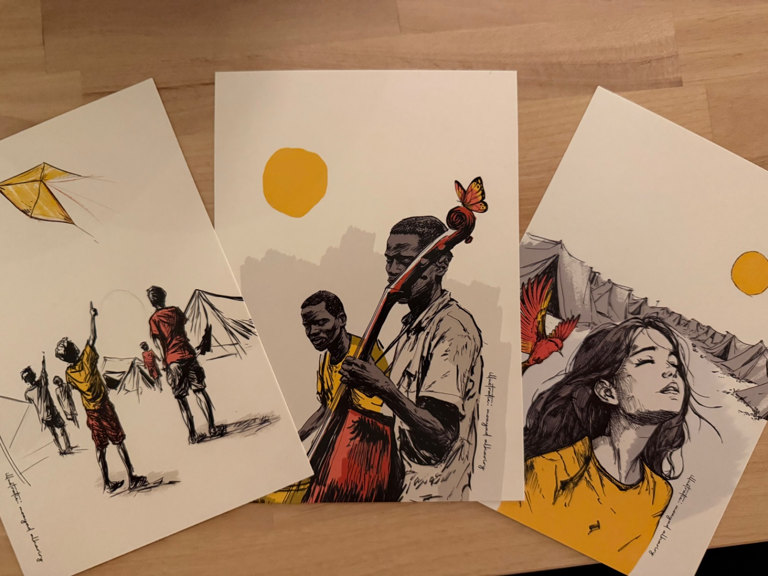 3 cards depicting drawn people under a yellow sun. One card with a girl enjoying the sun while in a refugee camp, one card with two men playing instruments, and one card with children playing with a kite