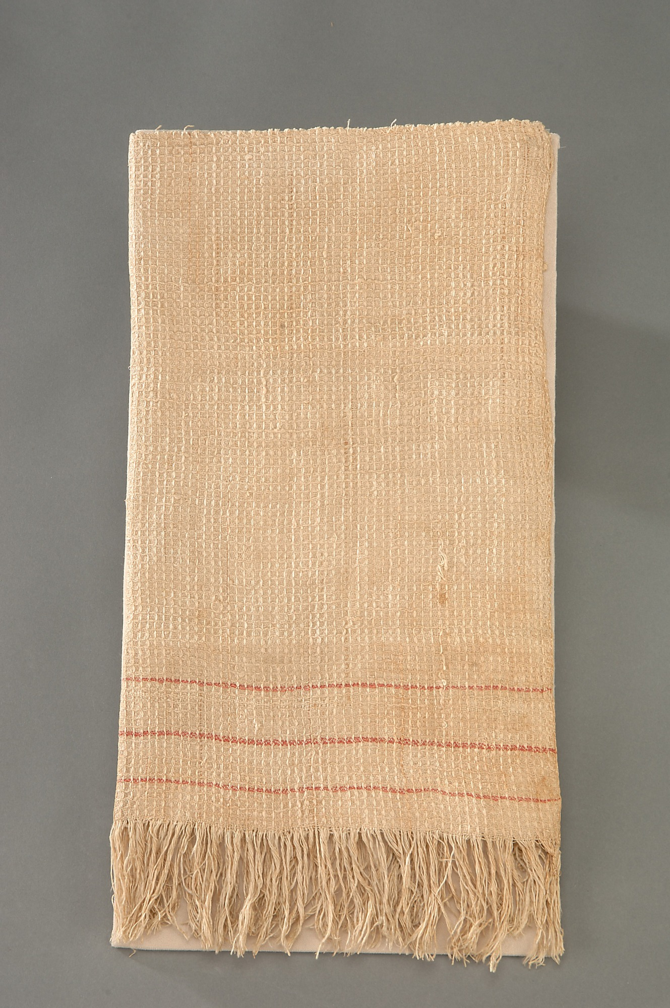 a tasteful white tea towel, waffle-weave, with three thin red stripes as accent used as the flag of surrender by the Confederacy
