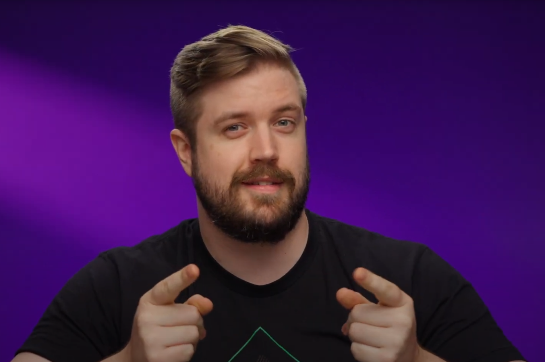 A screenshot of Luke from the Linus Tech Tips "What do we do now?" video as he strikes a dual fingerguns pose as he quirks his eyebrow and wears a grimace-like smile