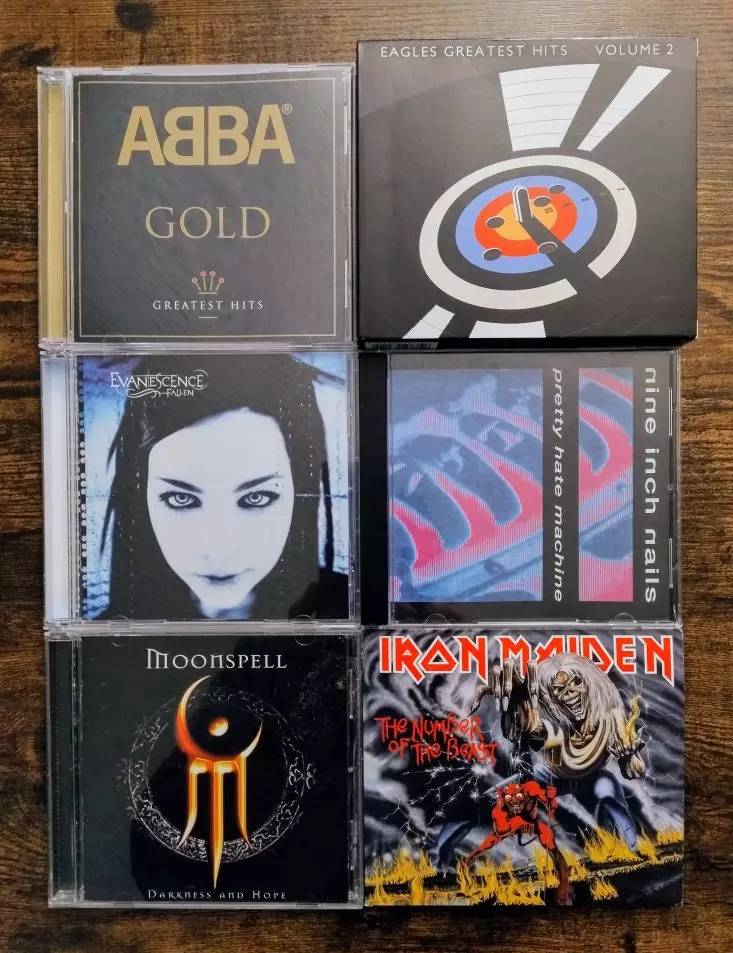 Group of varied CDs - ABBA Gold, Eagles Greatest Hits collection (volume 1 and 2), Evanescence Fallen, Moonspell Darkness and Hope, Nine Inch Nails Pretty Hate Machine, and Iron Maiden Number of the Beast